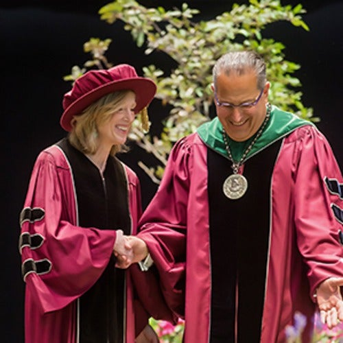 Sue Goldie shaking hands while receiving award.