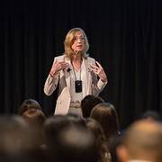 Sue Goldie presenting in front of audience