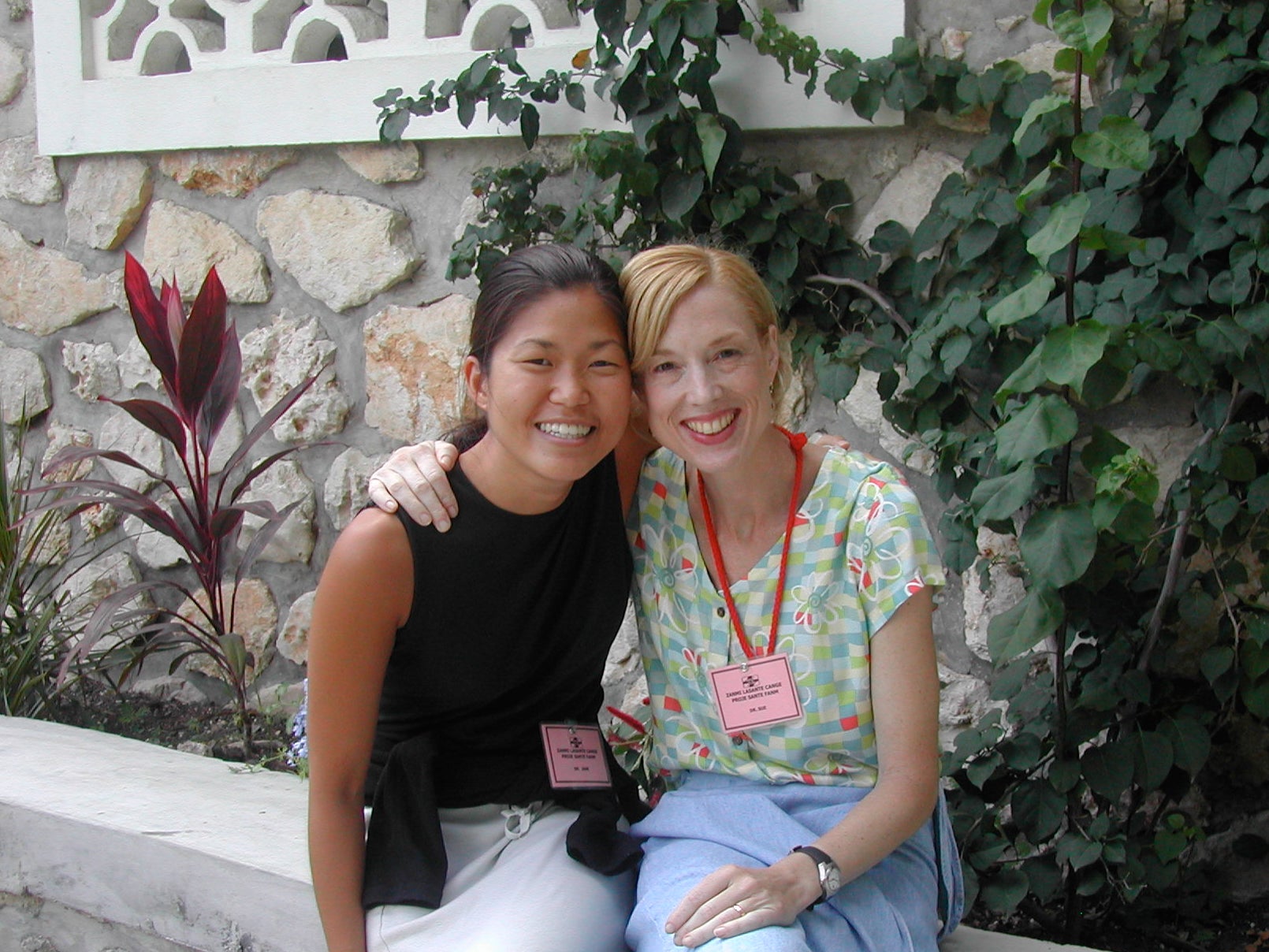 Jane Kim (left) and Sue J. Goldie (right) smile while seated on bench outdoors