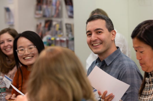 Photo of Mike Eber sitting during meeting smiling at camera