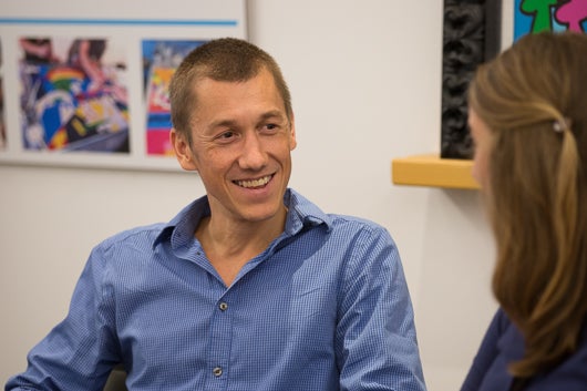 Nicolas Menzies Smiling Off-Camera Sitting in Meeting