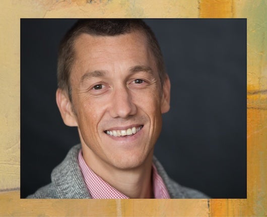 Headshot of Nicolas Menzies with abstract art border with yellow and orange tones