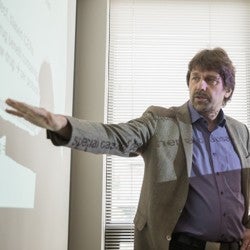 Uwe Siebert giving presentation in front of projector.