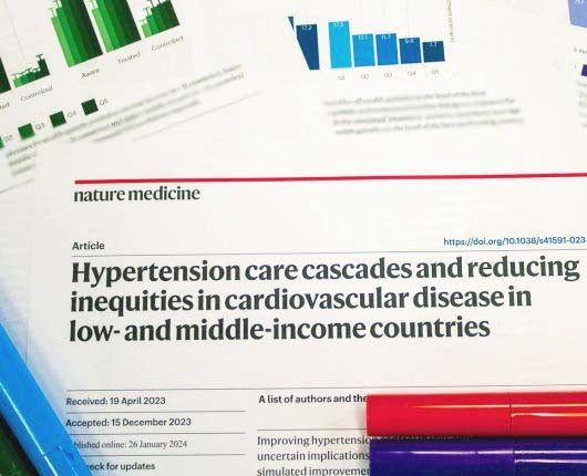 Image of a publication from Nature Medicine printed surrounded by markers